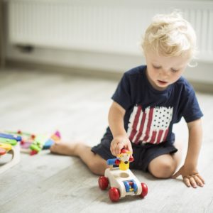bambino coccoloso che gioca con l'auto